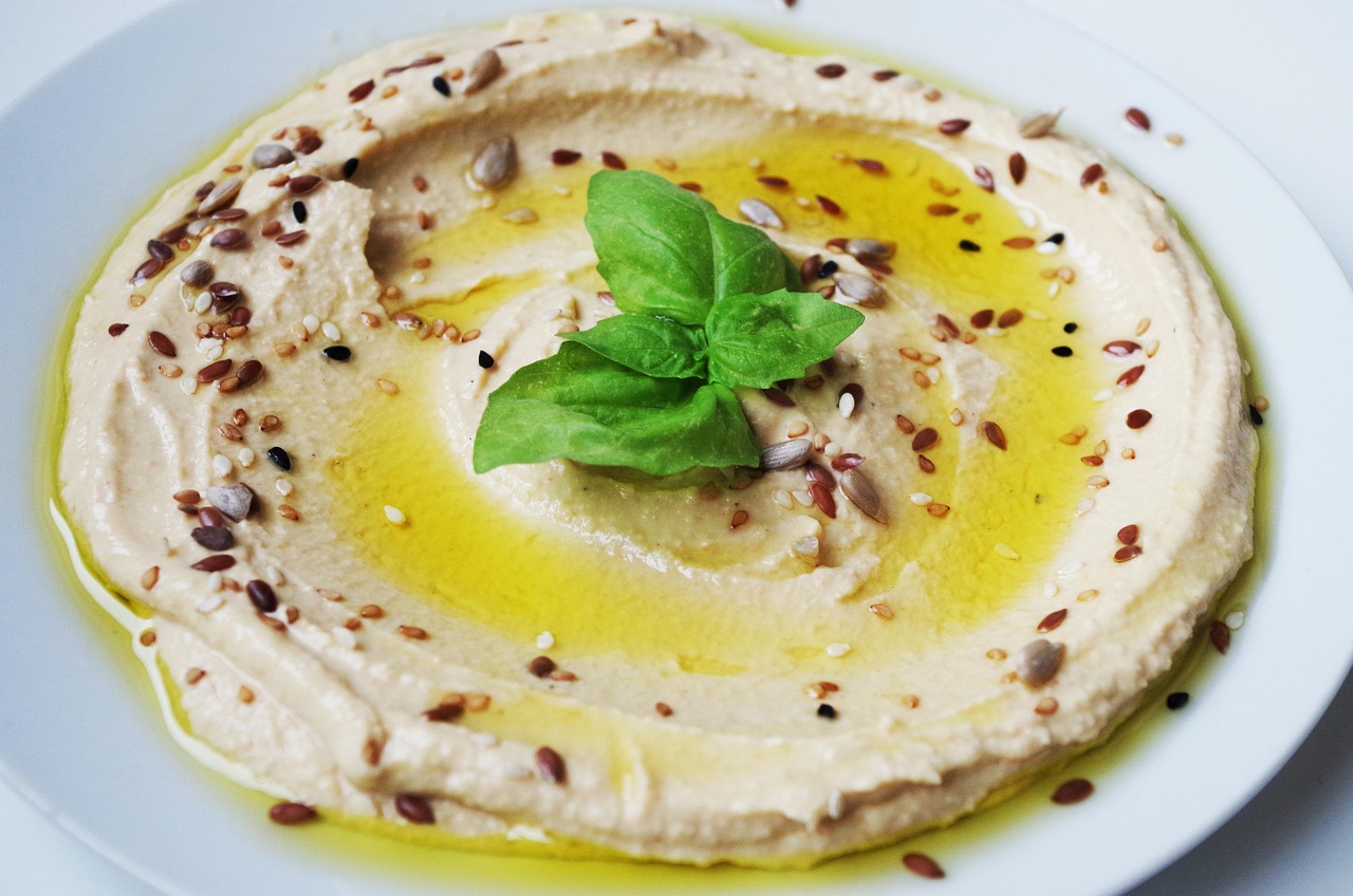 Hummus fatto in casa servito con verdure fresche per spuntini salutari.