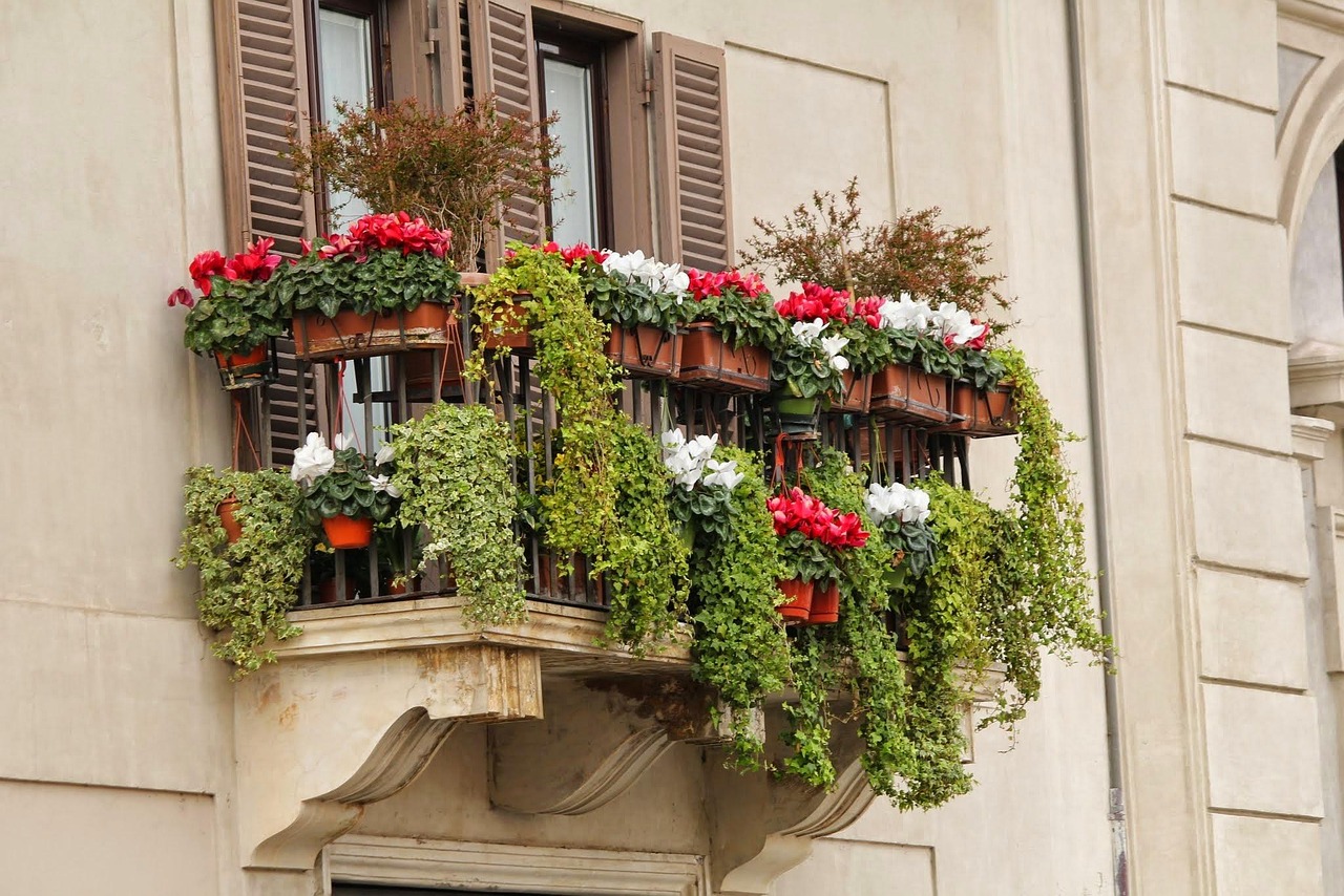 Mini orto sul balcone con piante verdi in vasi, spazio ottimizzato e ambiente urbano.