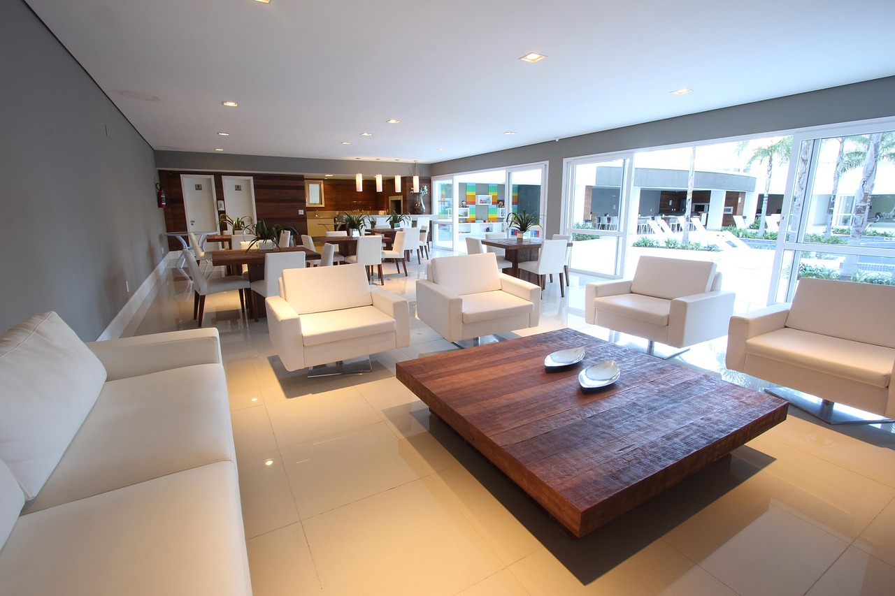 Salotto minimal con divano neutro, tavolino in legno e decorazioni semplici che creano un'atmosfera accogliente.