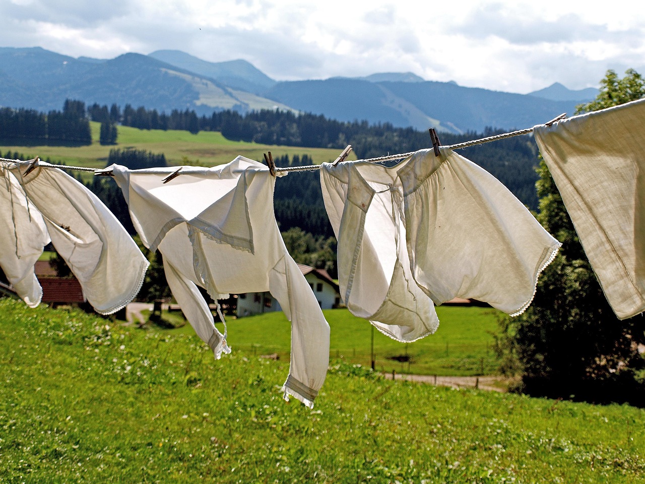Bambino che gioca all'aperto con erba sui vestiti, suggerendo rimedi naturali per rimuovere le macchie.