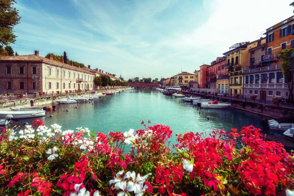 Fioriture primaverili in un paesaggio italiano con colline verdi e cielo azzurro.