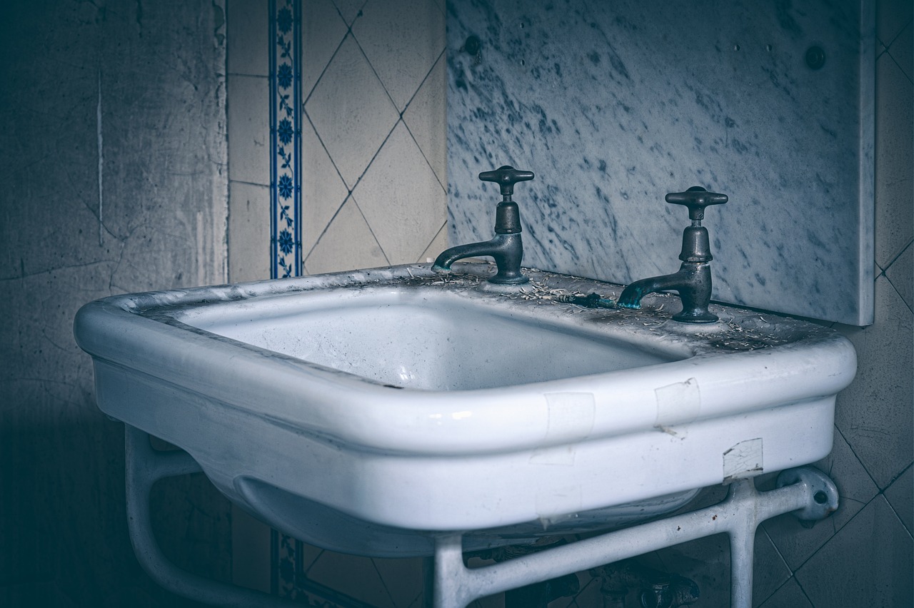 Immagine di muffa nera su parete di un bagno con attrezzi per la pulizia e prodotti anti-muffa.