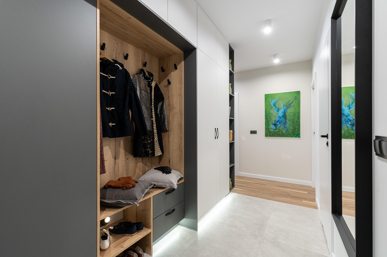 Ingresso di casa ben organizzato con soluzioni salvaspazio e arredi funzionali.