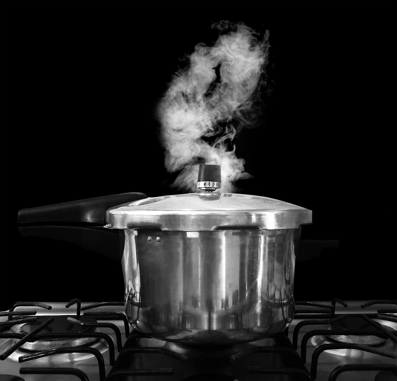Pentola a pressione su un piano di cottura con ingredienti pronti per la preparazione.